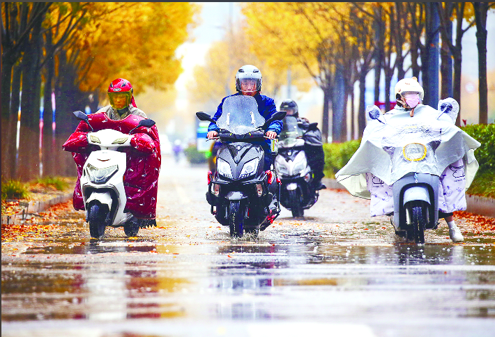 气温骤降 冒雨出行  